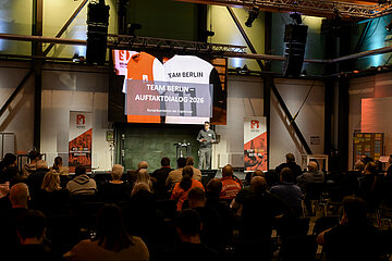 Menschen sitzen in einem Saal, während eine Person auf der Bühne vor einer großen Leinwand zum „Team Berlin – Auftaktdialog 2026“ spricht. Foto: Sandra Ritschel