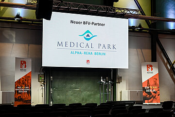 Bühne mit großem Bildschirm, der einen neuen BFV‑Partner zeigt; davor leere Sitzreihen und zwei Banner des Berliner Fußball‑Verbands. Foto: Sandra Ritschel