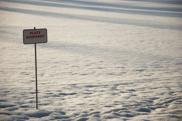 Schneebedecktes Spielfeld mit Schild: ‚Platz gesperrt‘. Keine Personen sichtbar, ruhige Winterlandschaft. Foto: BFV