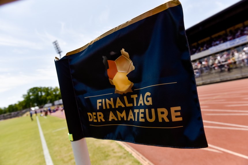 Eine Flagge mit der Aufschrift "Finaltag der Amateure" weht am Rand eines Sportplatzes. Foto: Sandra Ritschel