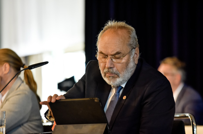 Joachim Gaertner im Anzug sitzt an einem Tisch und benutzt ein Tablet, während eine Frau neben ihm sitzt. Foto: Sandra Ritschel
