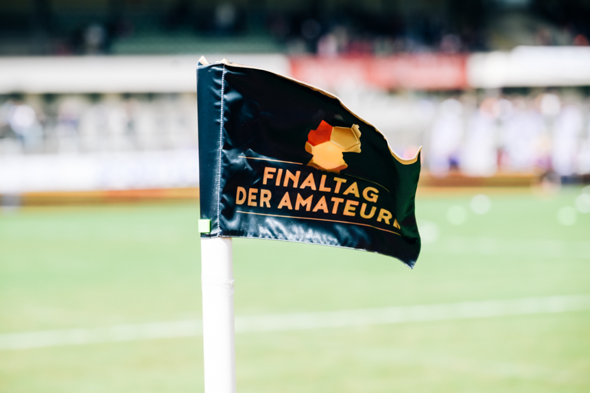 Eine schwarze Eckfahne mit der Aufschrift „Finaltag der Amateure“ steht auf einem Fußballfeld. Foto: Sandra Ritschel