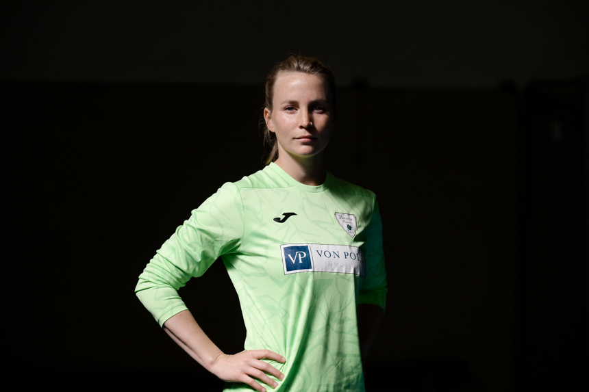 Eine Person im grünen Trikot mit „Joma“-Logo und „VP VON POLL IMMOBILIEN“-Sponsor steht mit Händen an den Hüften. Foto: Sandra Ritschel