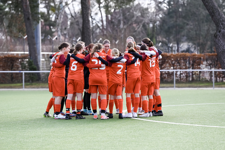 Ein Team in roten Trikots steht im Kreis auf dem Spielfeld und legt die Arme umeinander. Foto: Sandra Ritschel