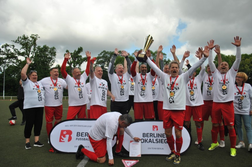 Eine Fußballmannschaft feiert den Berliner Pokalsieg 2025 auf dem Spielfeld, alle tragen Medaillen und heben jubelnd die Arme. Foto: BFV