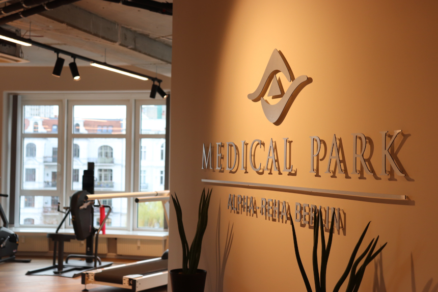 Innenraum eines Rehazentrums: An der Wand steht „Medical Park Alpha‑Reha Berlin“, daneben Trainingsgeräte, Pflanzen und große Fenster. Foto: BFV