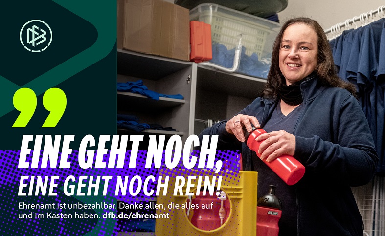 The picture shows a person holding a red drinking bottle and standing in a shelf space. Shelves with blue textiles and plastic boxes can be seen in the background. To the left of the picture is a graphic area with the logo of the German Football Association (DFB) and large text: "EINE GEHT NOCH, EINE GEHT NOCH REIN! Volunteering is priceless. Thank you to everyone who has everything up and running. dfb.de/ehrenamt".