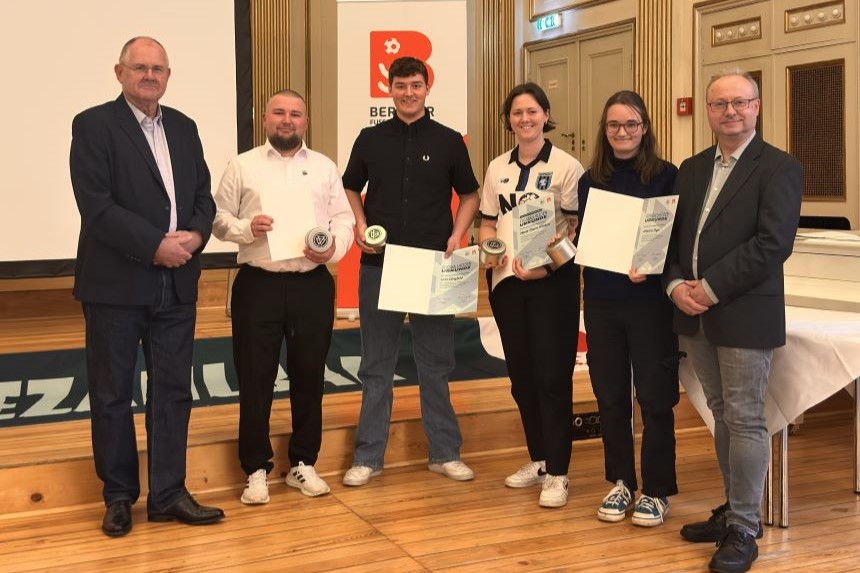 Sechs Menschen stehen in einem Saal, vier halten jeweils eine Urkunde in ihren Händen.